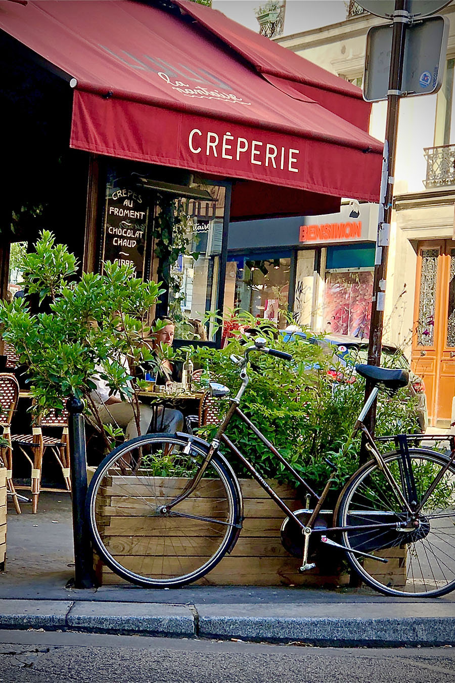 Devanture le "Lulu la Nantaise", une crêperie à Paris, avec une bicyclette posée sur le trottoir. ©2019 Mathieu Improvisato